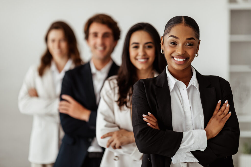 A group of people with sales and marketing jobs are standing with their arms crossed.